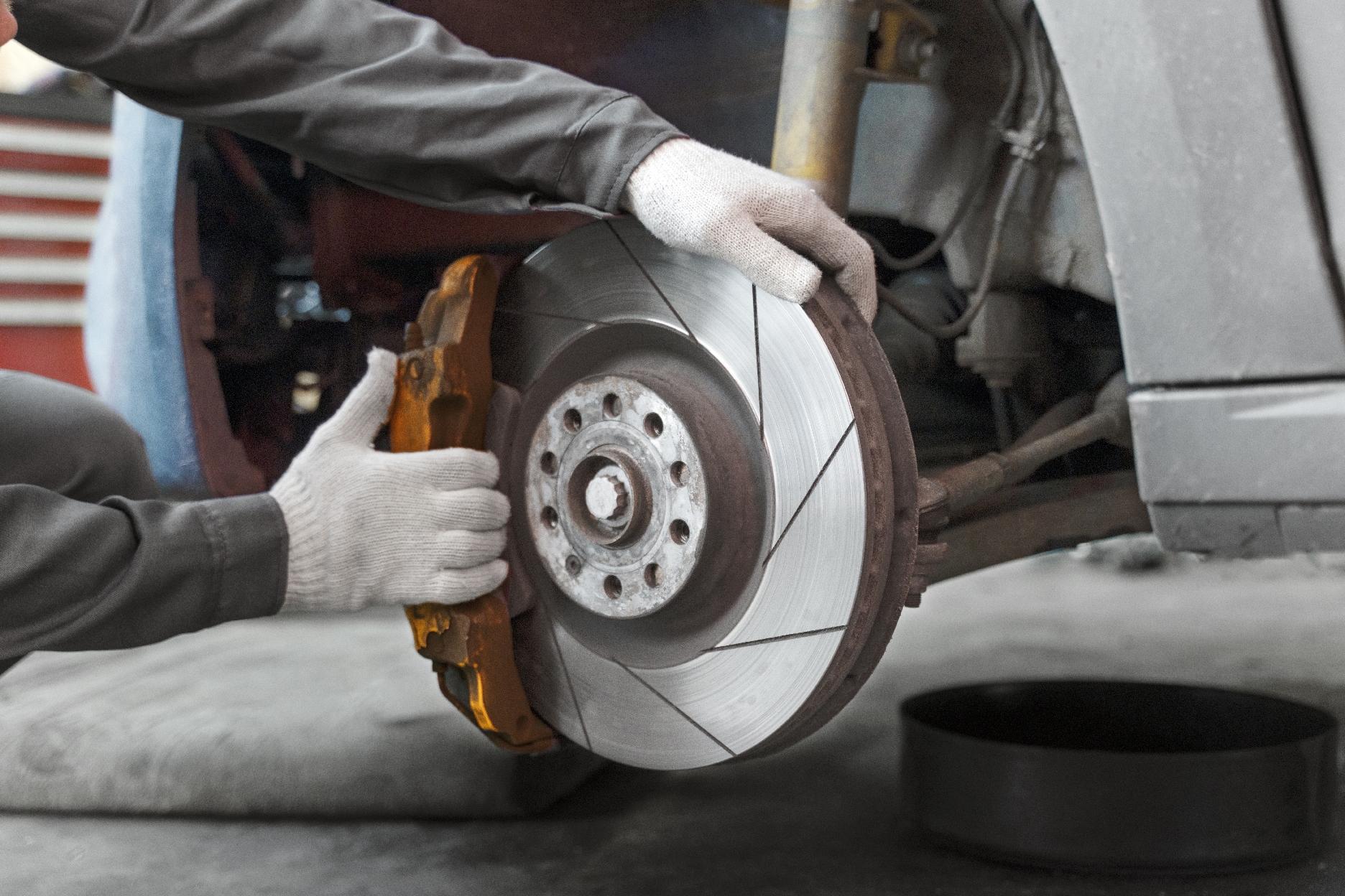 signs your brakes need attention with worker repairing brakes