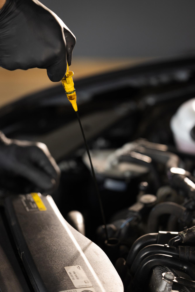 a mechanic checking the engine oil level before an oil change service